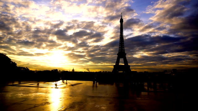 Grupo-de-turistas-mirando-la-Torre-Eiffel-con-fondo-puesta-de-sol