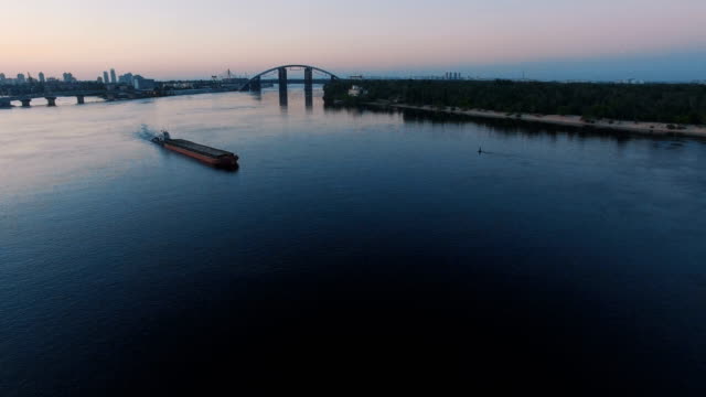 Schiff-fährt-entlang-des-Flusses-in-der-Nähe-der-Stadt-Port-auf-Sonnenuntergang-Luftaufnahmen