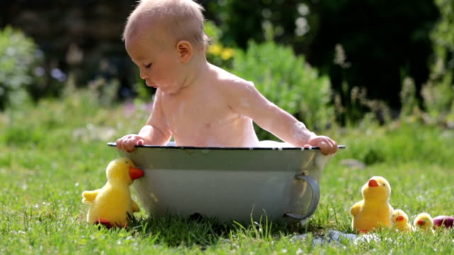 Niedlichen-Kind,-spielt-mit-kleinen-Häschen-und-Ostern-Eier-in-einen-blühenden-Garten,-Frühling.-Junge-mit-Kaninchen-spielen,-Ei-Jagd-für-Urlaub