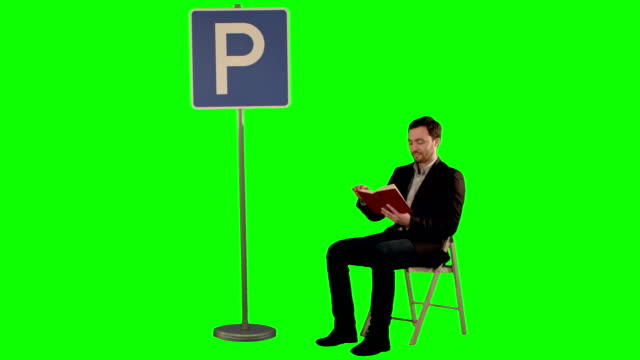 Junger-Mann-liest-ein-Buch-in-der-Nähe-von-Parkplatz-Schild-auf-einem-grünen-Bildschirm