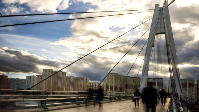 lots-of-people-walking-on-the-pedestrian-bridge-to-the-new-residential-area,time-lapse