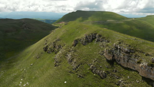 Eine-große-Felsformation-unter-den-grünen-Feldern-herumfliegen.-Russland.-Nord-Kaukasus