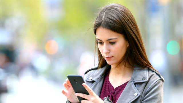 Ernsthafte-Teen-Outdoor-Smartphone-Inhalte-durchsuchen