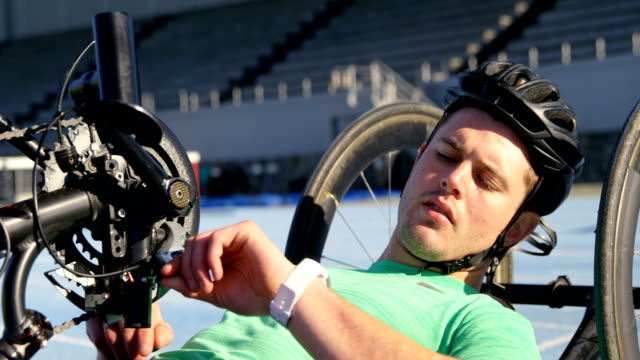 Disabled-athlete-using-smartwatch-on-a-running-track-4k