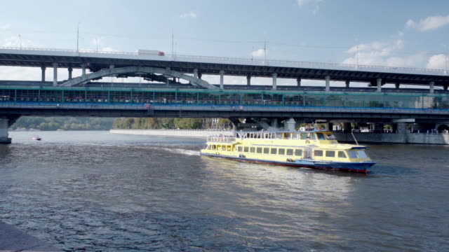 Amarillo-barco-navega-en-el-río-en-el-puente-de-fondo