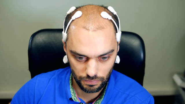 Man-wearing-robotic-Brainwave-Scanning-sensors-on-his-head,-close-up.