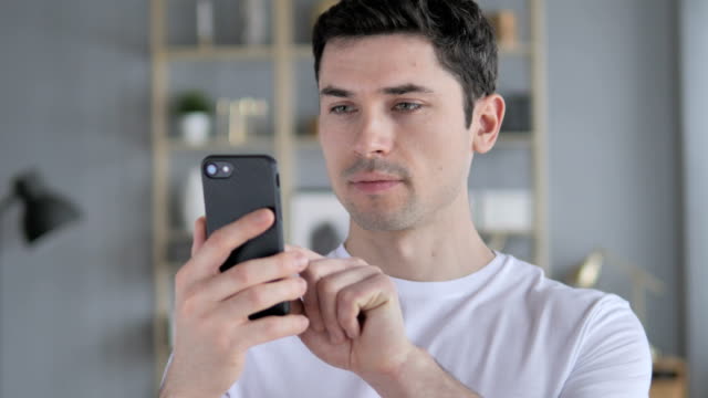 Porträt-des-jungen-Mannes-beschäftigt-mit-Smartphone