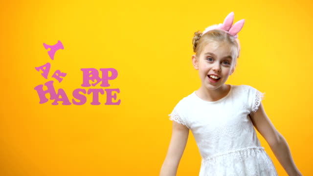 Happy-Easter-Zeichen,-begeistert-kleine-Mädchen-spielen-und-tanzen-mit-gefärbten-Eiern