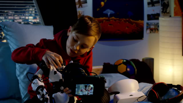 Boy-Film-Überprüfung-von-Spielzeugroboter