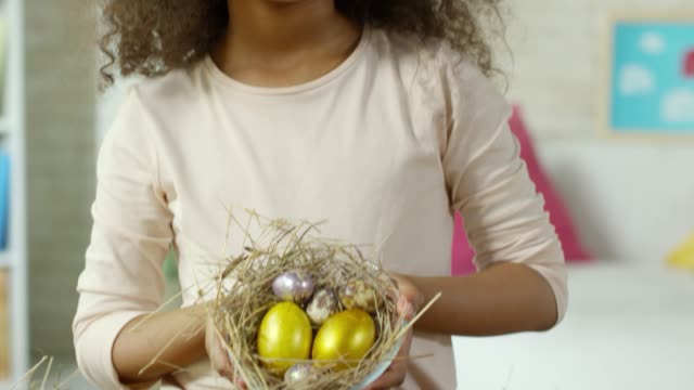 Linda-chica-africana-sonriendo-y-posando-con-huevos-de-Pascua