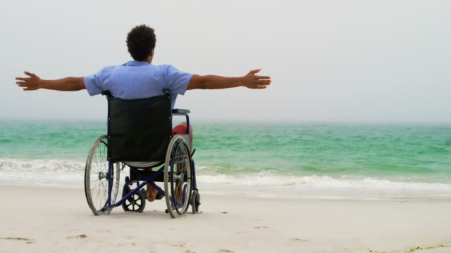 Rückansicht-des-afroamerikanischen-Mannes,-der-mit-ausgestreckten-Armen-auf-dem-Rollstuhl-sitzt-und-sich-ausdehnt