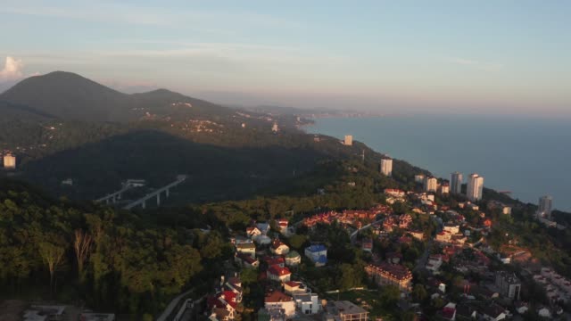 Aerial-video-shooting.-Sunset-over-the-city-of-Sochi.-Evening-light.-Haze-over-the-city.-Residential-area.-Black-sea-coast.-Panorama-shooting.-The-view-from-the-top.-Yellow-light