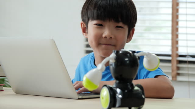 Boy-try-to-test-robots-in-school-science-club.-Project-for-engineering-club-in-school.-People-with-technology-concept.
