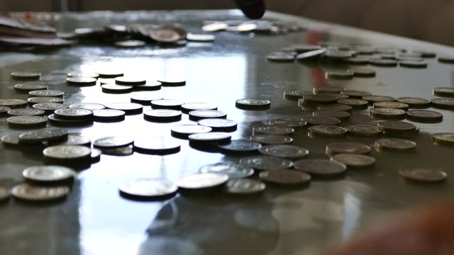 counting-coins,-counting-metal-money-in-a-grocery-store,