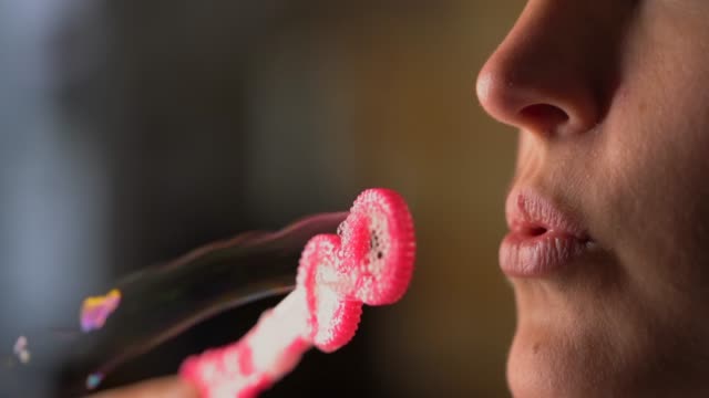 Nahaufnahme-Makro-Lippen-blasen-Blasen-aus-rosa-Blase-Zauberstab
