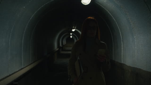 Lächelnde-Frau-klingelt-am-Telefon-im-Tunnel