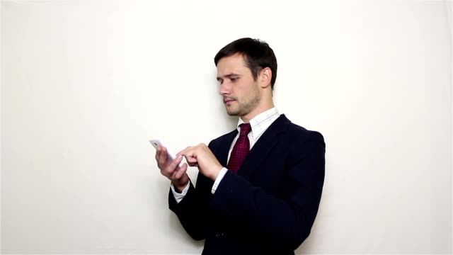 Young-handsome-businessman-leafing-through-news-feed-on-his-smartphone.