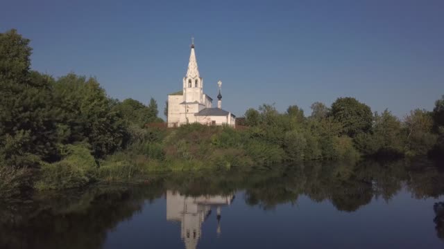 Flug-über-den-Fluss-und-schöne-Kirche-in-Susdal.-Russland.-Luftaufnahme-von-Drohne