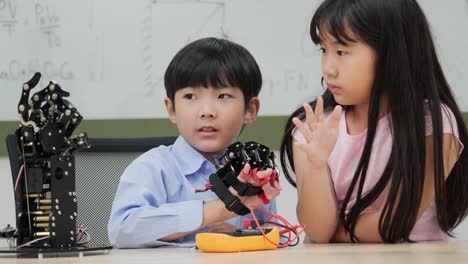 Los-niños-están-jugando-con-el-brazo-robótico-en-una-escuela.-Lo-están-controlando-a-mano.