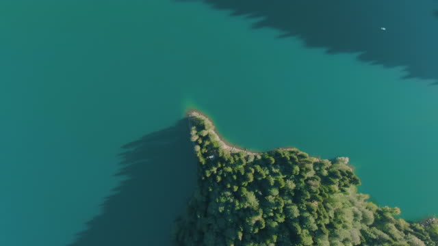 Bergsee-mit-türkisfarbenem-Wasser-und-grünem-Baum