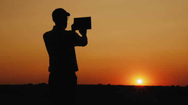 Silhouette-eines-Mannes,-der-den-Sonnenuntergang-fotografiert