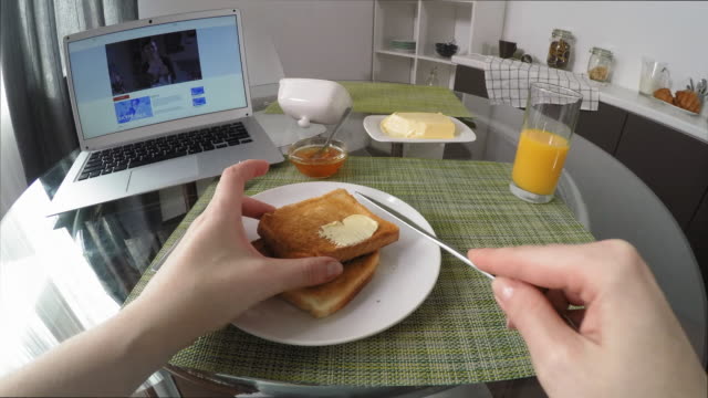 POV-of-Woman-Having-Breakfast-and-Watching-Series-on-Laptop