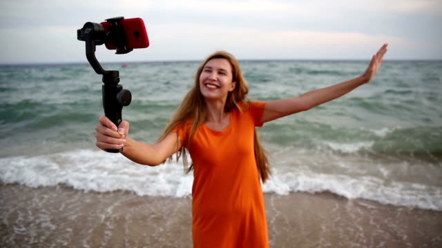 Glückliche-Frau-macht-Selfie-am-Strand.