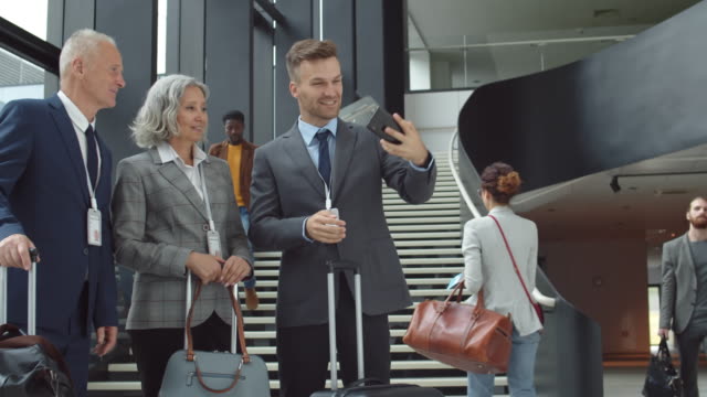 Drei-Geschäftspartner-machen-Selfie-am-Flughafen