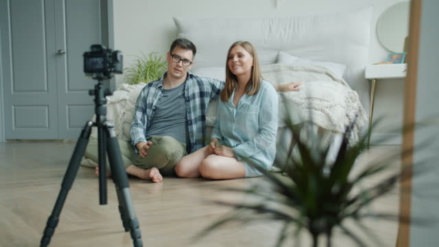 Mädchen-und-Kerl-Vlogger-Recoding-Video-für-vlog-zeigt-Daumen-up-sprechen-zu-Hause