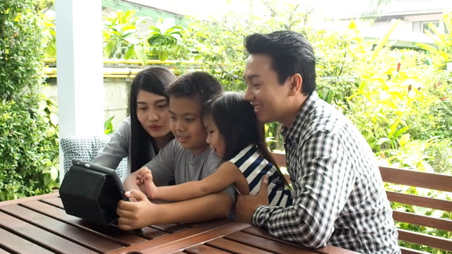 asia-Familie-sieht-Tablet-glücklich-zusammen