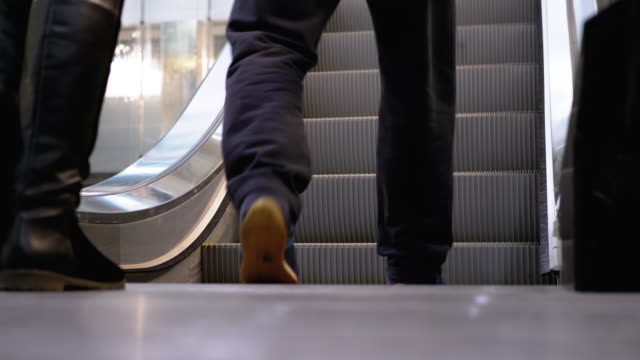 Legs-of-People-Moving-on-an-Escalator-Lift-in-the-Mall.-Shopper's-Feet-on-Escalator-in-Shopping-Center