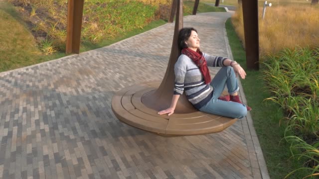 Kaukasische-Frau-sitzt-auf-einer-Parkbank-geschlossen-ihre-Augen