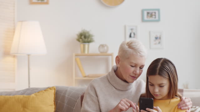Caucasian-Granny-Teaching-Girl-How-to-Use-Smartphone