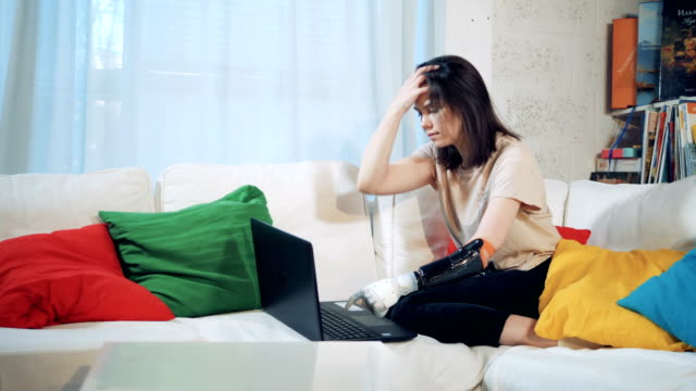 Una-persona-trabaja-con-un-ordenador-portátil,-usando-prótesis-biónica,-de-cerca.