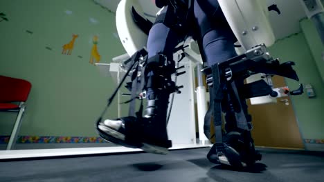 Close-up-of-walking-legs-tied-up-with-belts-of-a-simulating-machine