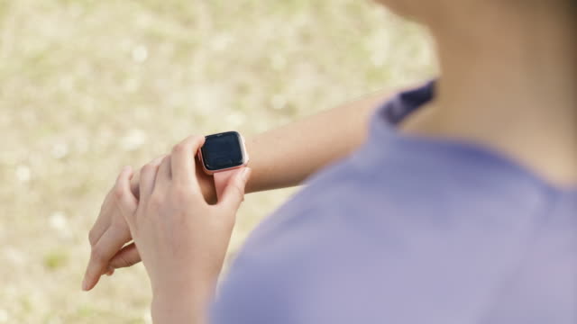 Close-up-athlete-checking-fitness-progress-on-her-smart-watch-after-running-workout.
