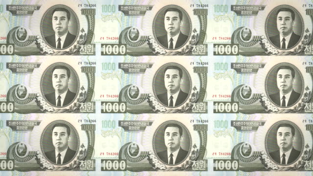 Billetes-de-mil-wons-de-Corea-del-Norte-rodando,-dinero-en-efectivo,-bucle