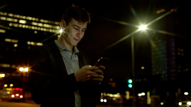 Handsome-guy-is-texting-while-standing-on-a-street