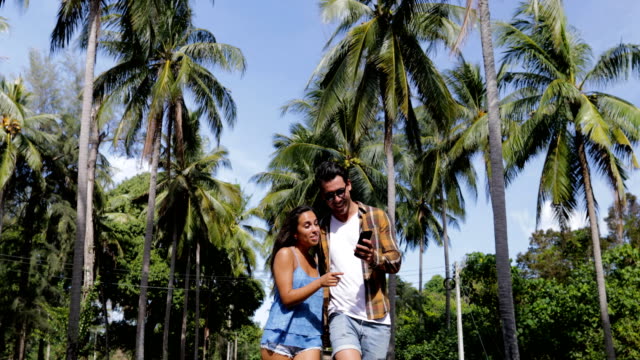 Paar-im-Freien-mit-Smart-Handy-Spaziergang-Selfie-Foto-unter-Palmen-reden,-glücklich-lächelnden-Mann-und-Frau-Kommunikation