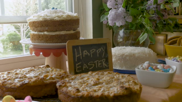 Ostern-Desserts-und-ein-Zeichen,-das-frohe-Ostern-an-eine-Tafel-sagt