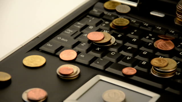 Münzen-auf-einem-Laptop-isoliert-auf-weißem-Hintergrund