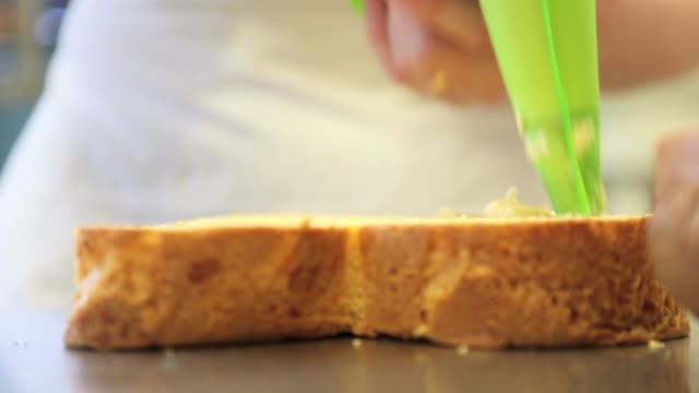 Pastry-Chef-Hände-gefüllt-Ostern-süßes-Brot-Kuchen-mit-Pudding,-Nahaufnahme-auf-der-Arbeitsplatte-in-der-Konditorei