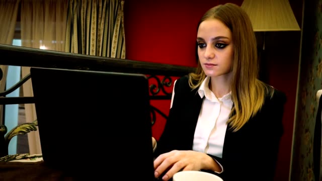 Junge-Geschäftsfrau,-die-Eingabe-auf-Laptop-Text-sitzen-im-restaurant