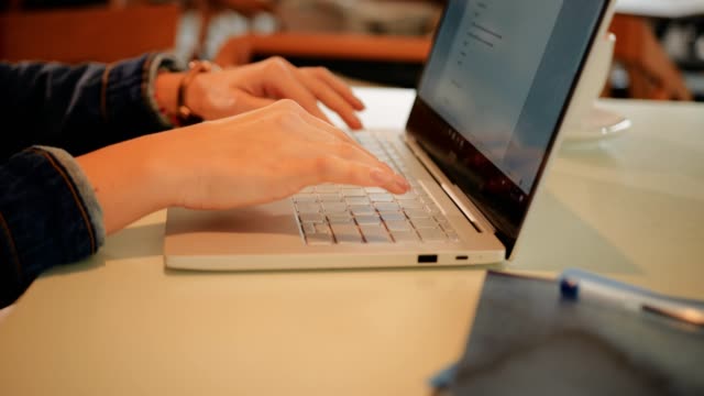 Estudiante-de-Universidad-femenino-usando-laptop-y-hacer-la-tarea-en-el-café