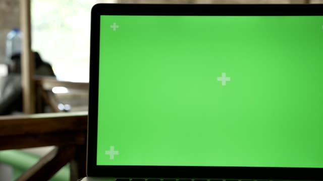Close-moving-shot-of-laptop-display-with-chromakey-in-office-with-working-people