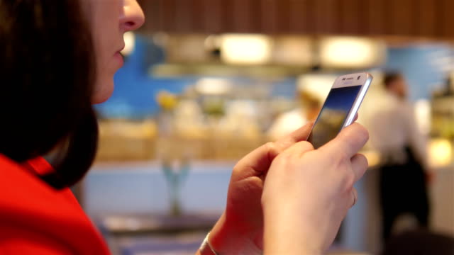 Woman-using-mobile-phone-in-the-restaurant-in-4k-slow-motion-60fps
