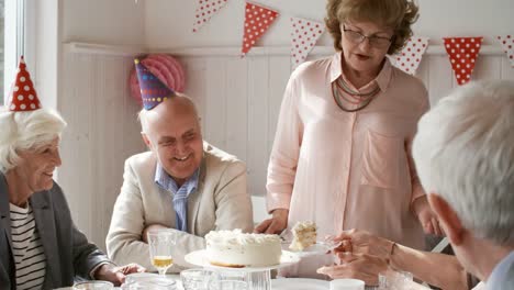 Senior-Friends-Having-Birthday-Cake-at-Dinner-Party