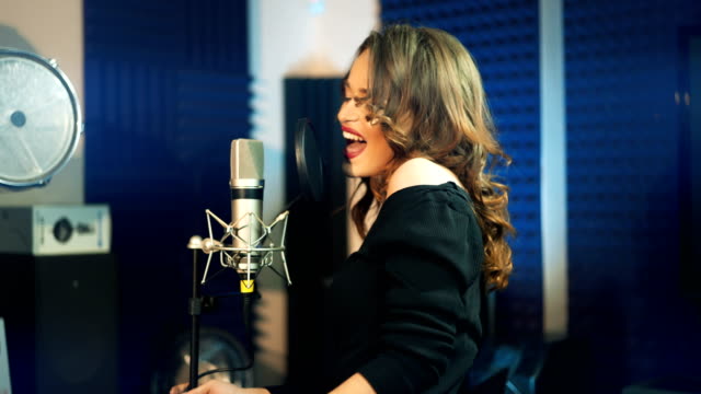 Mädchen-singen,-das-Mikrofon-in-einem-Studio.