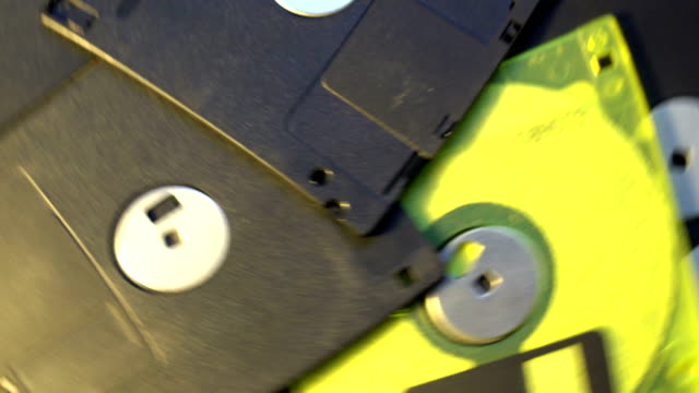 pile-of-old-style-data-transfer-floppy-discs,-rotating-spinning-background