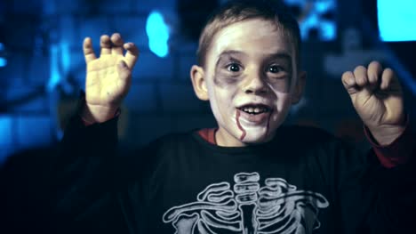 Beängstigend-kleiner-Junge-Schädel-geschminkt-für-Halloween-mit-Fingern-zu-erschrecken